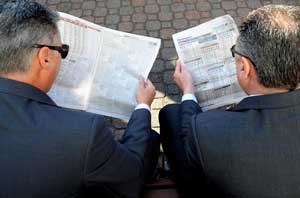 Men reading racing form guide